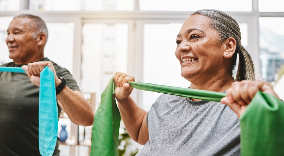 Older adults using resistance bands for light strength exercise, supporting mobility and healthy aging