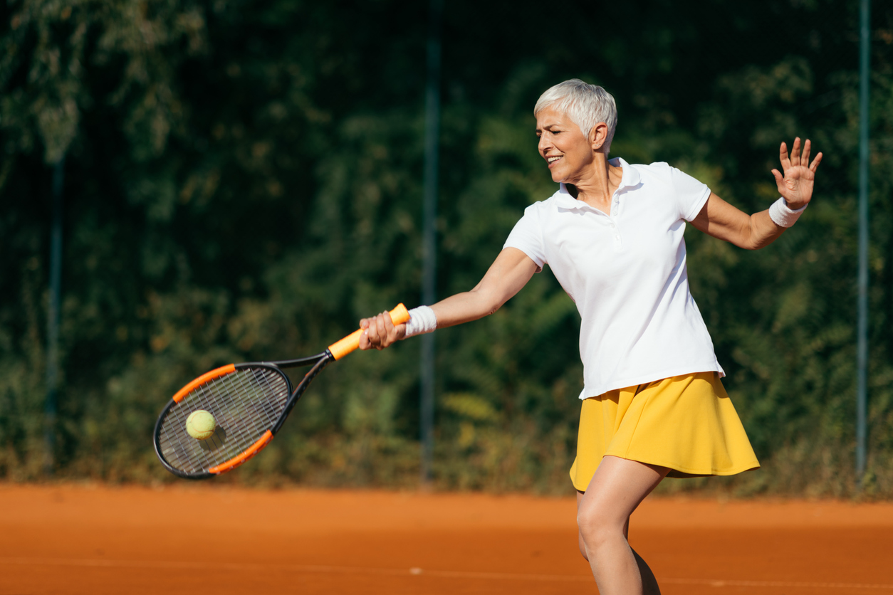 Older woman playing tennis, illustrating how someone can remain active even when changes in bone density are not noticeable.